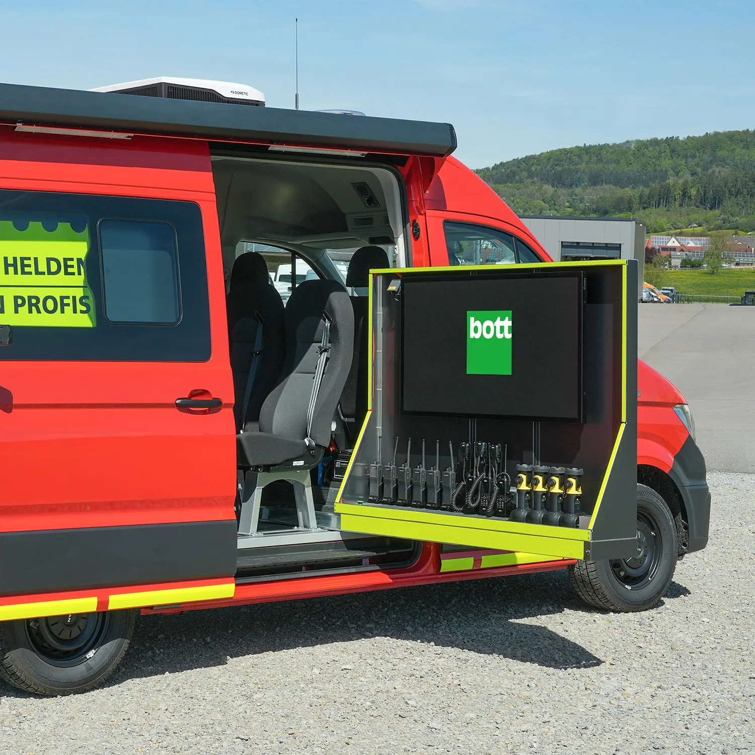 Einsatzleitfahrzeug mit ausgezogenem Funk- und Monitormodul von bott neben dem Mannschaftsraum